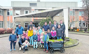 Kinderen Ronde Tafel Lochem delen bloemen uit op De Hoge Weide
