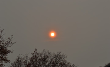 Hoe komt het dat de zon vandaag zo oranje is?