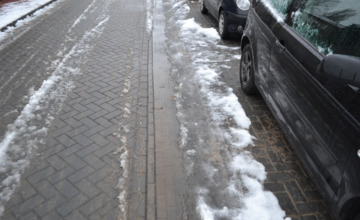 Natte schoenen of een flinke smakkerd maken door Warnsveldse regengoot